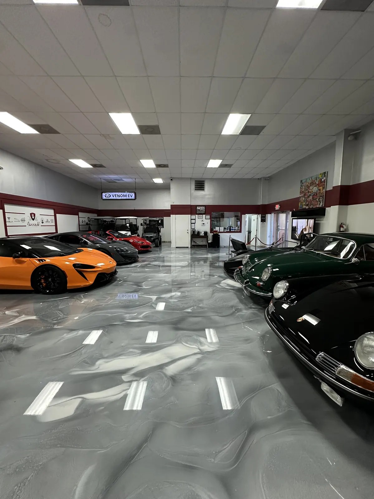 Gray metallic epoxy showroom floor at Barrett Auto Gallery with luxury cars, view 4