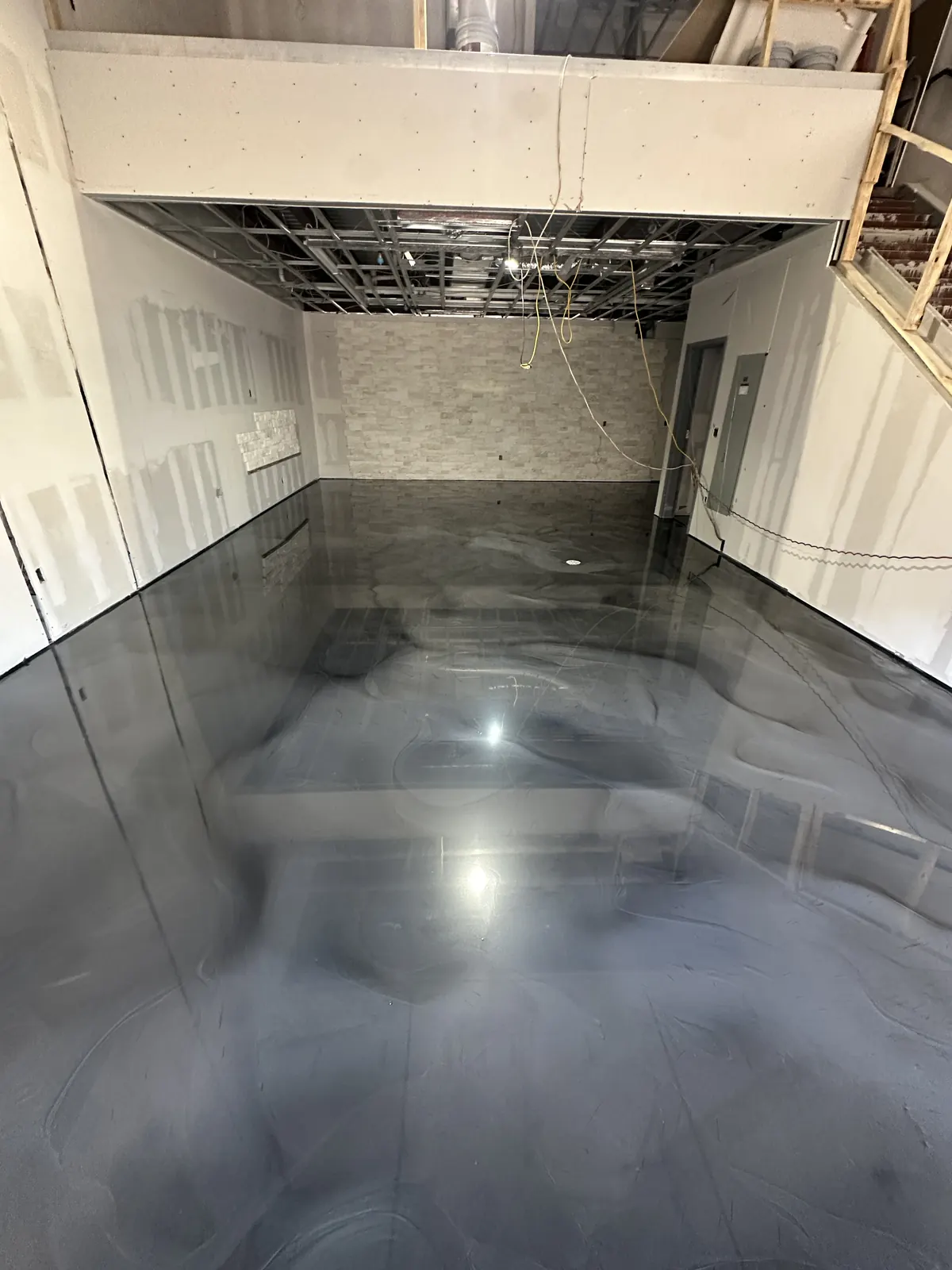 Black and white metallic epoxy garage floor with car lifts, view 3