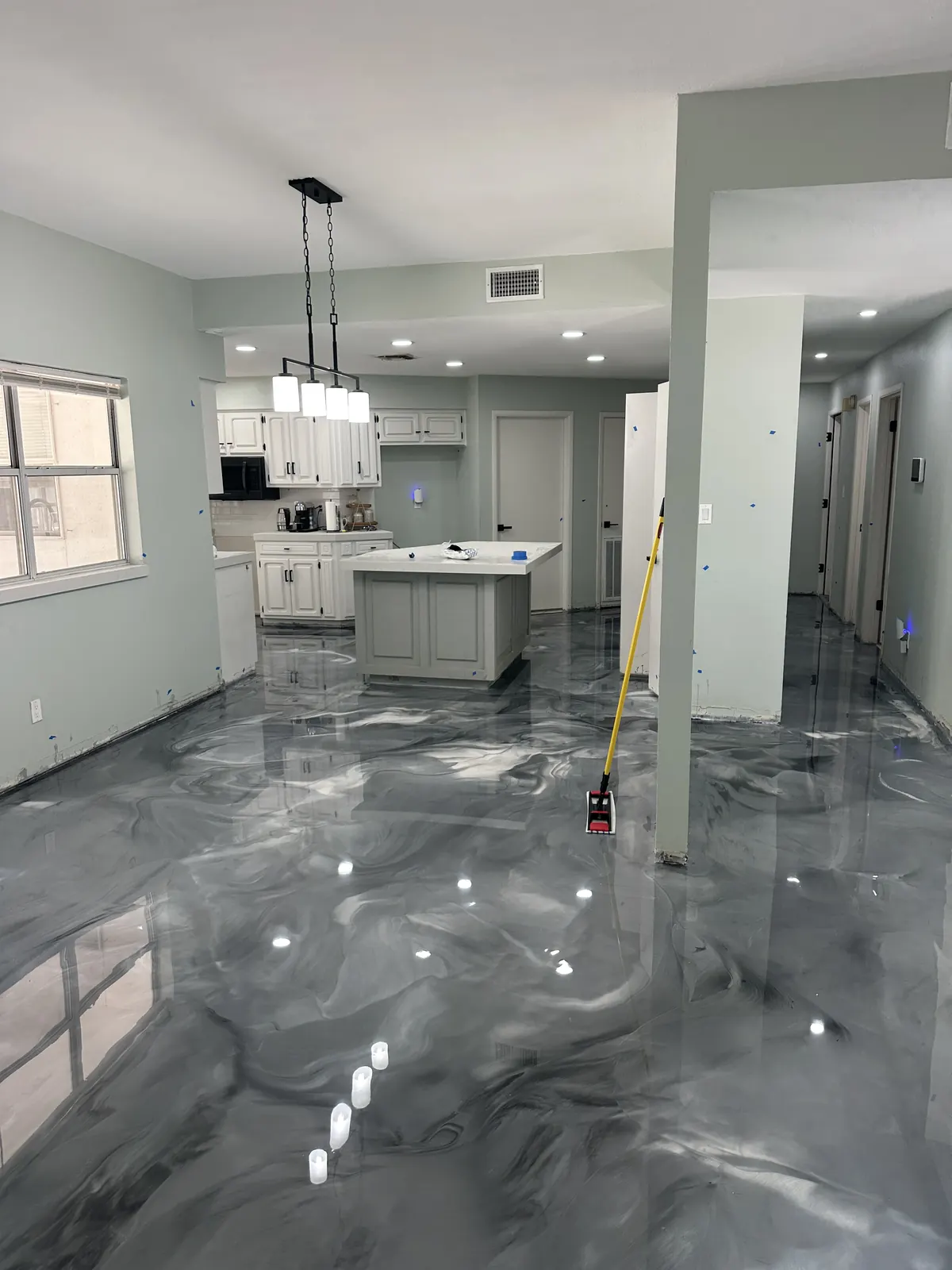Gray and white metallic epoxy floor in an open kitchen and living area