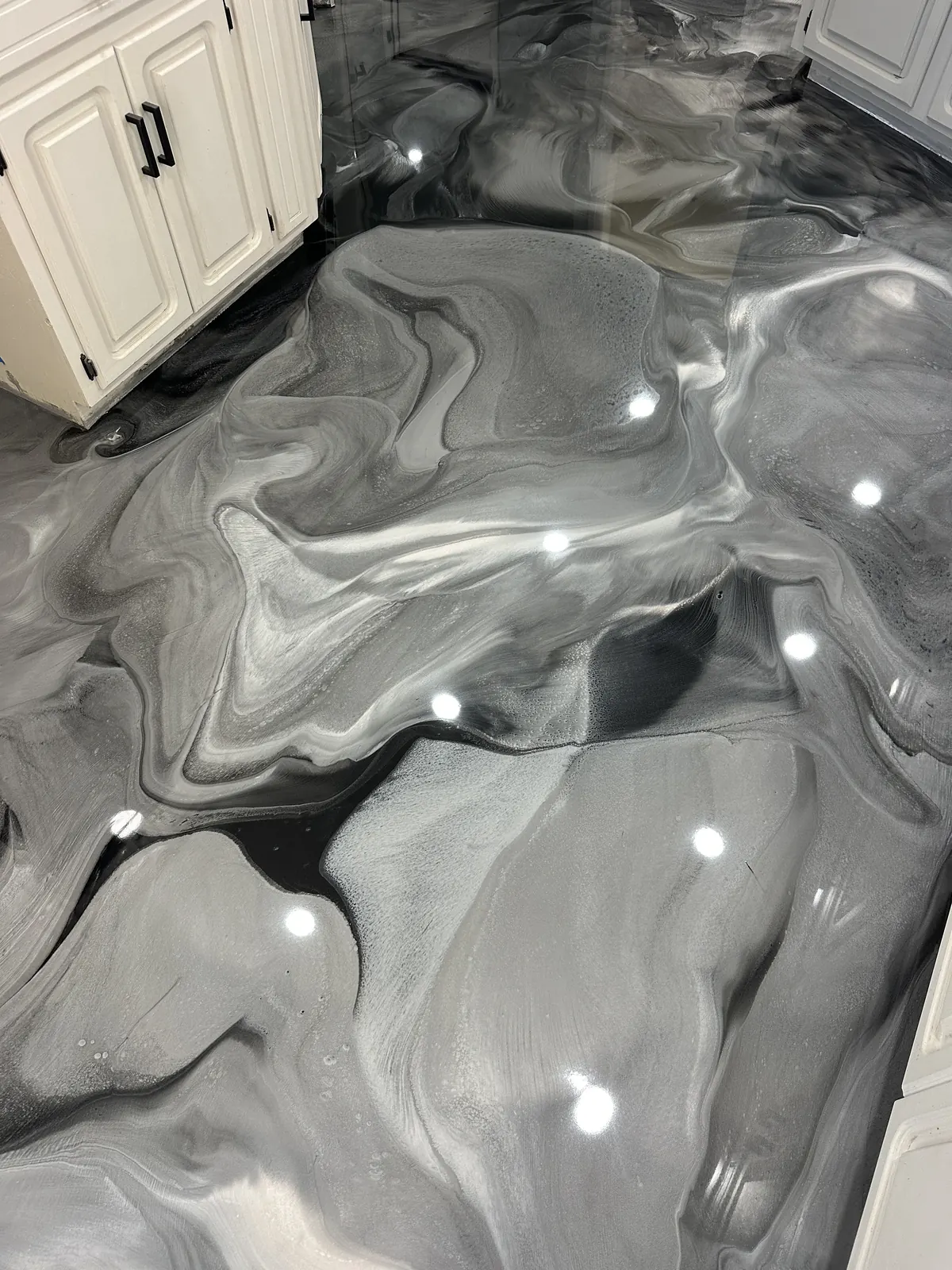 Gray and white metallic epoxy floor in an open kitchen and living area, view 2