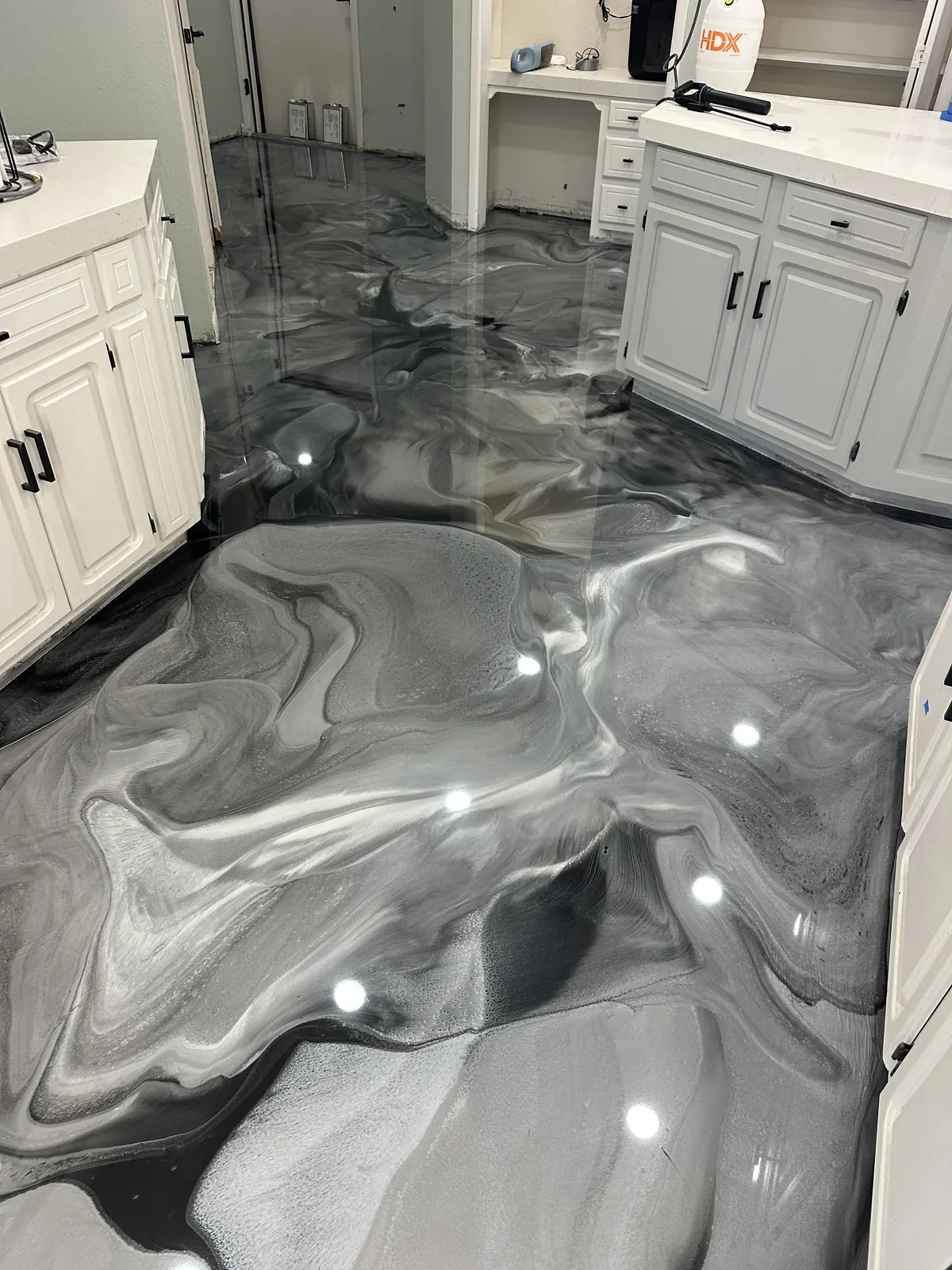 Gray and white metallic epoxy floor in an open kitchen and living area, view 3