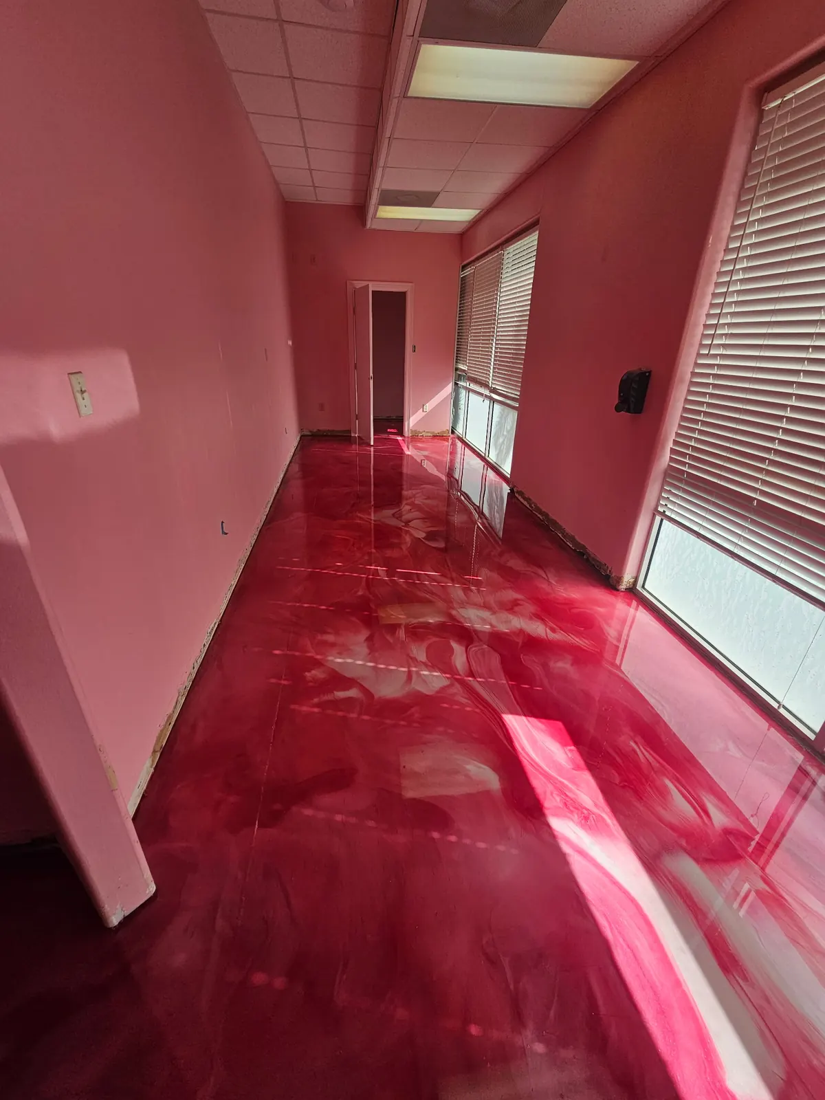 Red metallic epoxy floor in a bright interior room, view 2