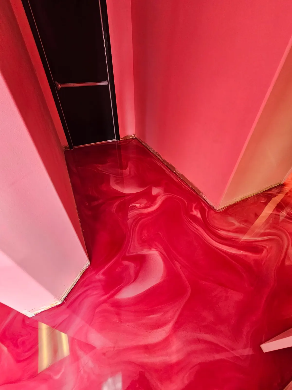 Red metallic epoxy floor in a bright interior room, view 4