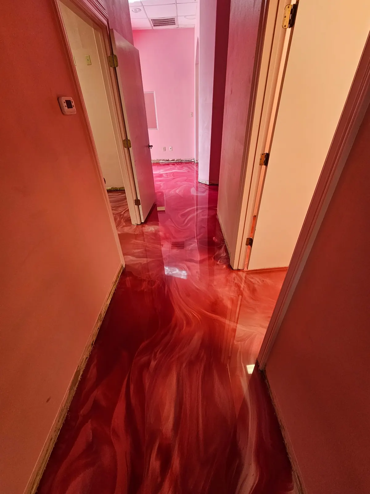 Red metallic epoxy floor in a bright interior room, view 9