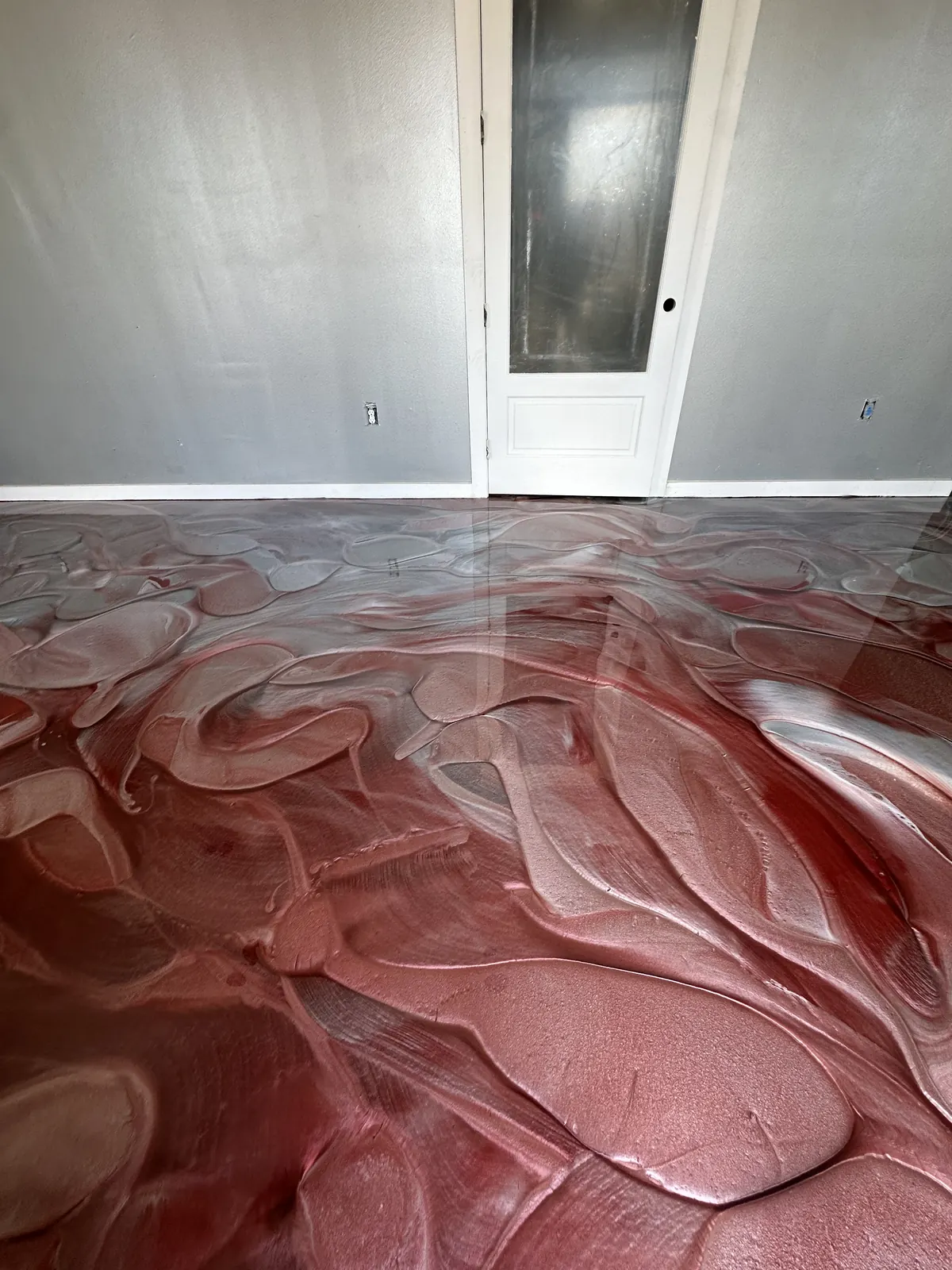 Red and silver metallic epoxy floor in an office hallway