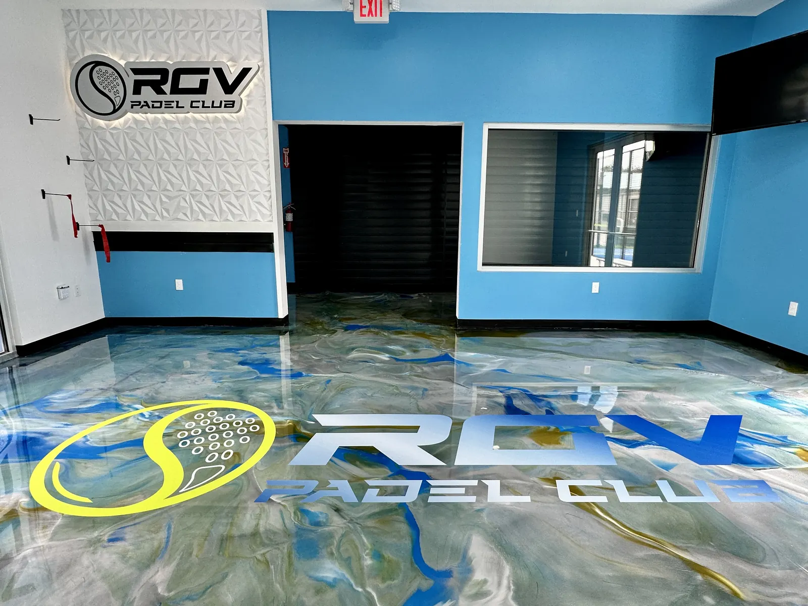 Blue and gold metallic epoxy floor with the RGV Padel Club logo