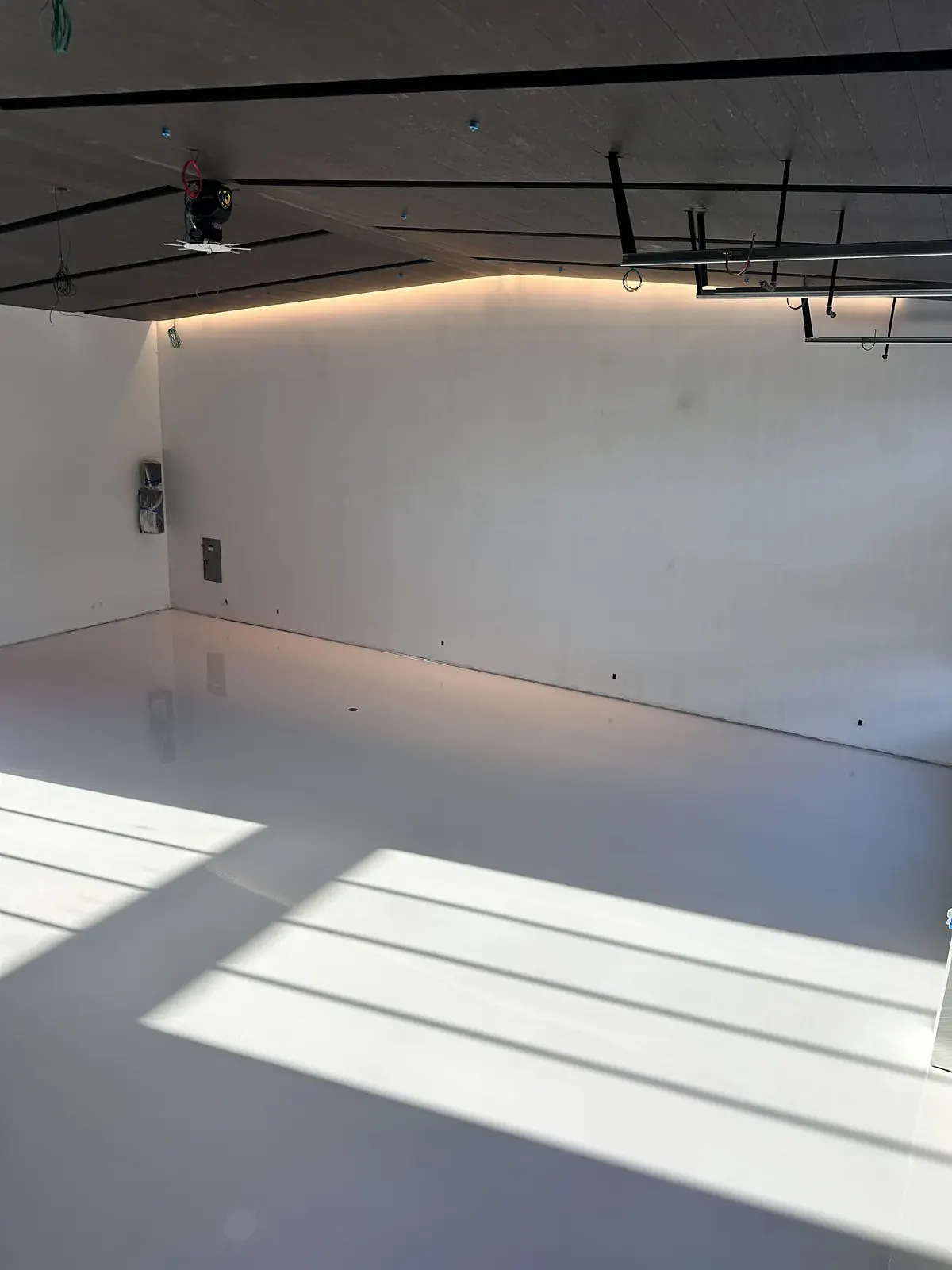 Light gray solid-color epoxy floor in a studio space, view 2